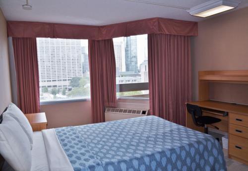 a bedroom with a bed and a desk and a window at Chestnut Residence and Conference Centre - University of Toronto in Toronto