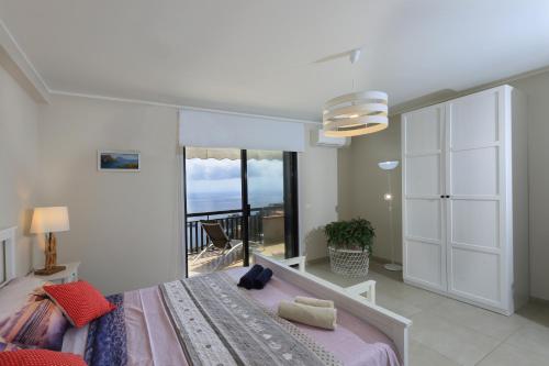 una camera da letto con un letto grande e una grande finestra di Olimpia's House a Taormina