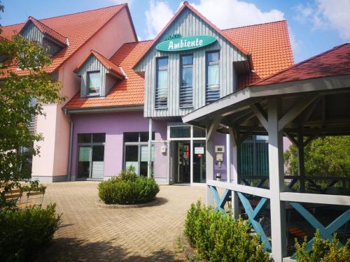 - un bâtiment coloré avec un panneau indiquant un emplacement dans l'établissement Hotel Ambiente, à Halberstadt