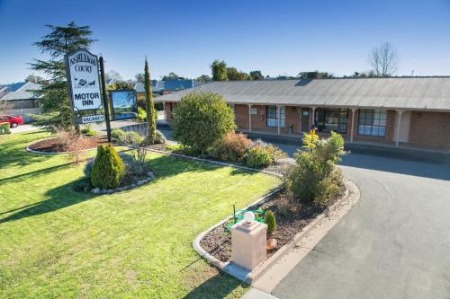 a sign in front of a building with a street at Ashleigh Court Motor Inn in Mulwala