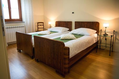 a bedroom with a large wooden bed with two pillows at Guesthouse Muha in Lipica
