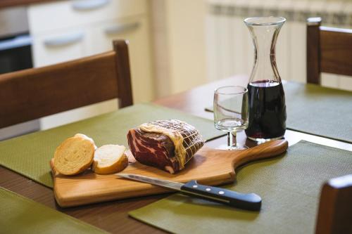 a cutting board with a loaf of bread and a glass of wine at Guesthouse Muha in Lipica