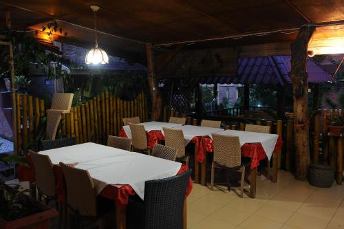 a dining room with white tables and chairs with red bows at Toba Village Inn in Tuk Tuk