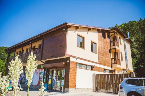 a building with a car parked in front of it at Стаи за гост Хит Хаус и СПА in Bratsigovo