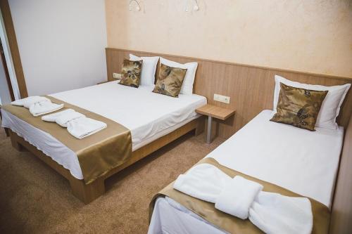 two beds in a hotel room withskirts at Стаи за гост Хит Хаус и СПА in Bratsigovo