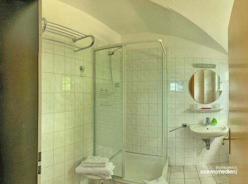 a bathroom with a shower and a sink at Hotel & Restaurant Am Bodden in Putbus