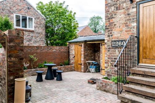 a patio with black stools in front of a brick building at City Apartments - Priory Street in York