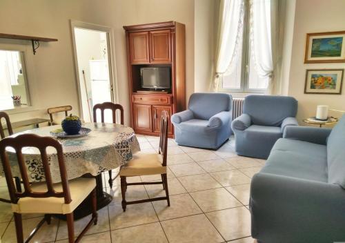 een woonkamer met een tafel en stoelen en een televisie bij Casa Scalini in Como