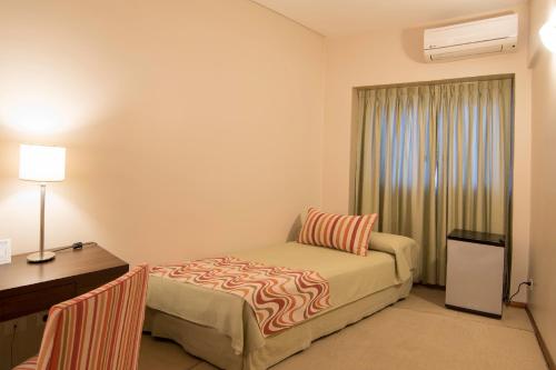 1 dormitorio con cama, escritorio y ventana en Hotel Intersur San Telmo en Buenos Aires