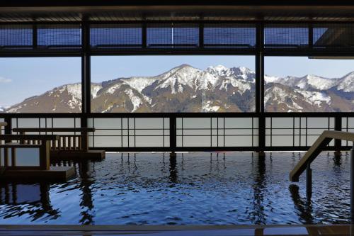 湯沢町にある湯けむりの宿 雪の花のスイミングプールから山脈の景色を望めます。