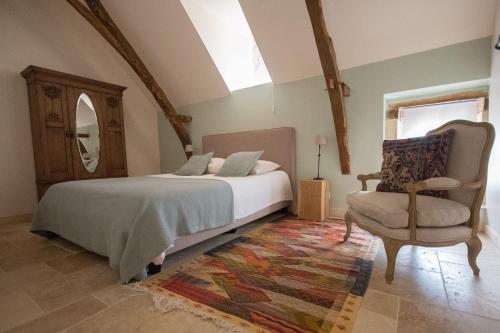 オリアック・デュ・ペリゴールにあるMaison du Cèdreのベッドルーム1室(ベッド1台、椅子、鏡付)