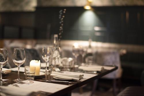 a table with wine glasses and a candle on it at Lahinch Coast Hotel and Suites in Lahinch