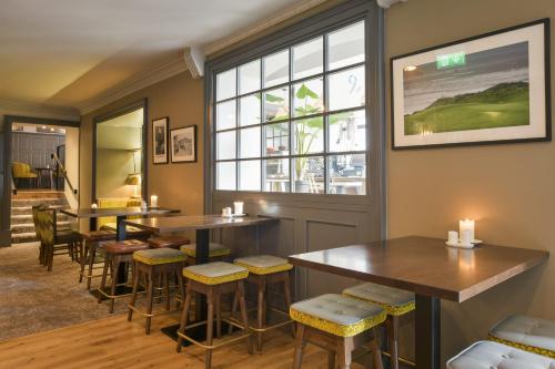 a restaurant with tables and chairs and a window at Lahinch Coast Hotel and Suites in Lahinch