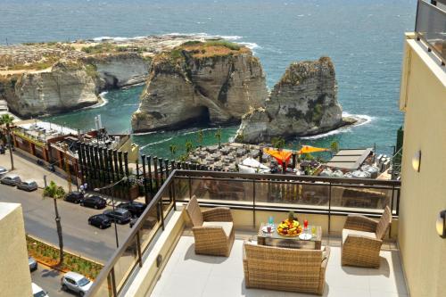 een balkon met stoelen en uitzicht op de oceaan bij La Vida Suite in Beiroet