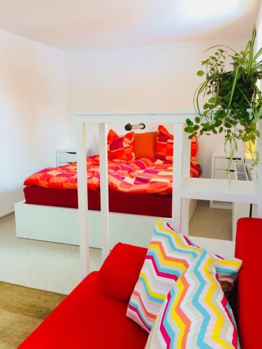a bedroom with a bed and a red couch at Pension SPORT-SCHMIEDE in Schmiedefeld am Rennsteig