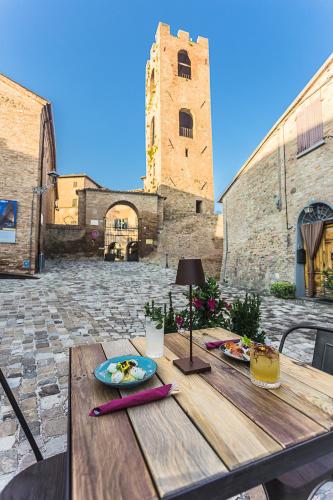 a wooden table with a plate of food on it at Malatesta Antica Dimora in Longiano