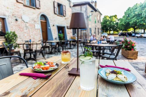 a wooden table with two plates of food and a drink at Malatesta Antica Dimora in Longiano