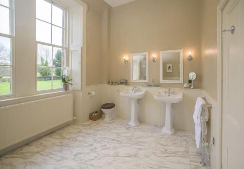 baño grande con 2 lavabos y ventana en The Sculleries at Thirlestane Castle en Lauder