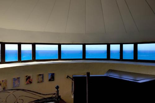 a group of windows in a room with the ocean at Mythica Tower Mill - Windmill Beach House in Ialyssos