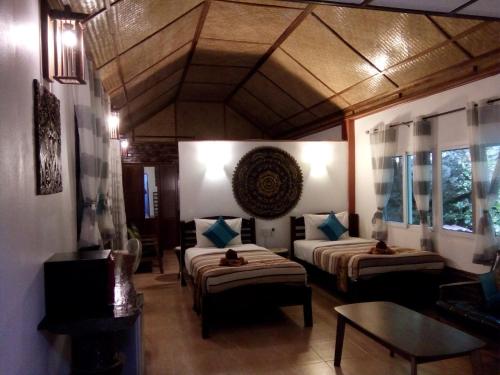 a hotel room with two beds and a table at Hotel Khaosok and Spa in Khao Sok