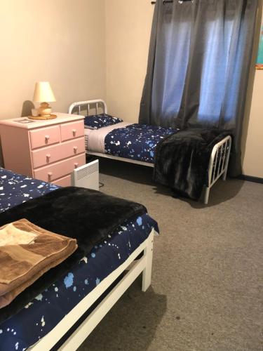 1 dormitorio con 2 camas individuales y vestidor en Home away from home, en Merredin