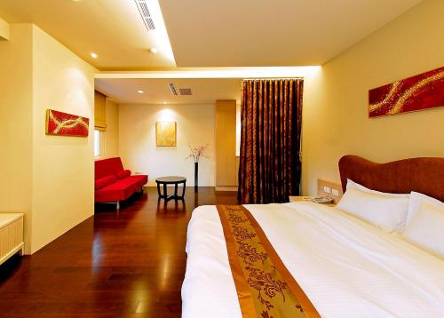 a hotel room with a bed and a red couch at Sun Moon Lake Karuizawa Villa in Yuchi