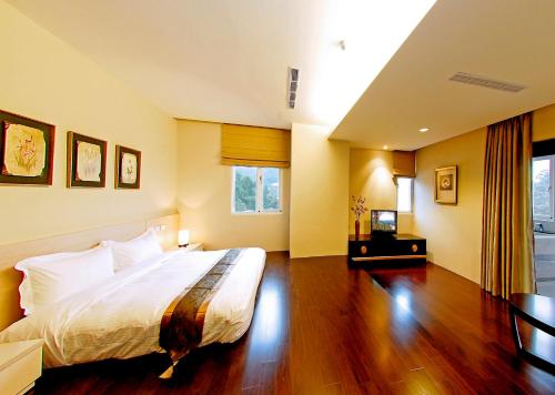 a bedroom with a large bed and a wooden floor at Sun Moon Lake Karuizawa Villa in Yuchi