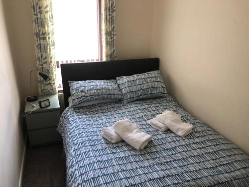 a bedroom with a bed with two white towels on it at Claire’s AirBNB 2 in Belfast