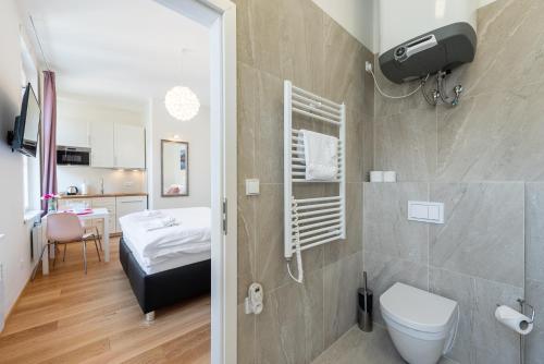 プラハにあるTesnov Residence Apartmentsのバスルーム(トイレ付)、ベッド1台が備わります。