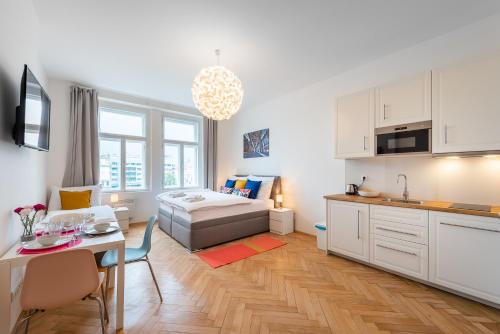 een keuken en een woonkamer met een bed en een tafel bij Tesnov Residence Apartments in Praag
