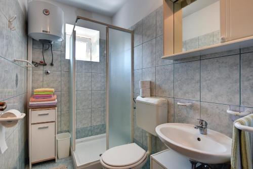 a bathroom with a toilet and a sink at Apartments Lorencin in Medulin