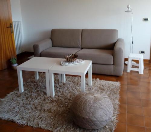 sala de estar con sofá y mesa de centro blanca en Mansarda a 50 metri dal mare, en Porto SantʼElpidio