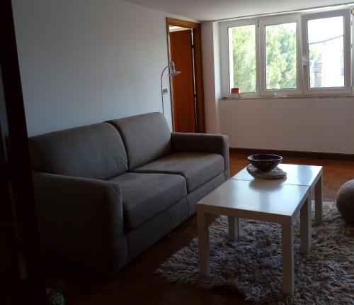 sala de estar con sofá y mesa de centro en Mansarda a 50 metri dal mare, en Porto SantʼElpidio