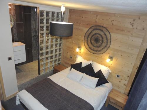 um quarto com uma cama e uma parede de madeira em LAUZIERE 1266/68 em Arc 1800