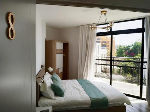 a bedroom with a bed and a large window at Cohen's Jaffa Rooms in Tel Aviv