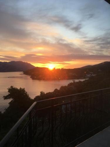 a sunset over a river with the sun in the distance at THE VIEW **** in Račišće
