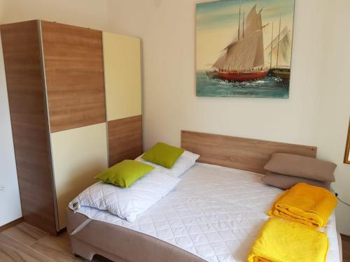 a bedroom with a bed with a sailboat on the wall at studio apartman Lanterna in Tribunj