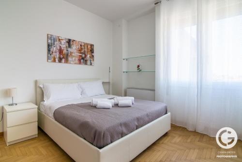 ein Schlafzimmer mit einem Bett mit zwei Handtüchern darauf in der Unterkunft YPA APARTMENTS STORIONE in Padua