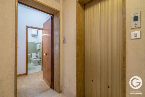 einen Flur mit Tür zu einem Bad mit WC in der Unterkunft YPA APARTMENTS STORIONE in Padua