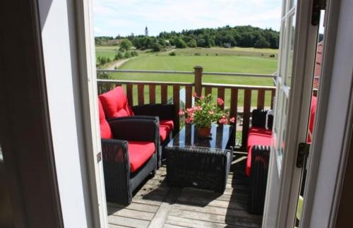 d'un balcon avec des chaises et une table donnant sur un champ. dans l'établissement Apartment in the countryside in Tossene Hunnebostrand, à Hunnebostrand