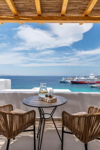 a table and chairs on a balcony with a view of the ocean at Avra Mykonos in Tourlos