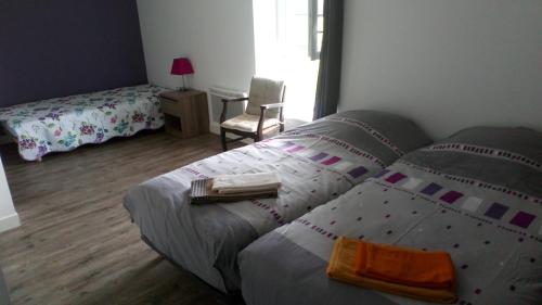 a bedroom with a bed and a table with two books at Chez Julien in Montviron