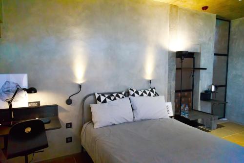 a bedroom with a large bed with white pillows at Sengal Boutique Hotel in Auroville