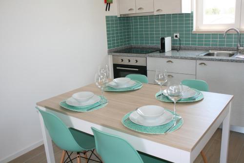 a kitchen with a table with plates and wine glasses at Recantus Comporta in Comporta