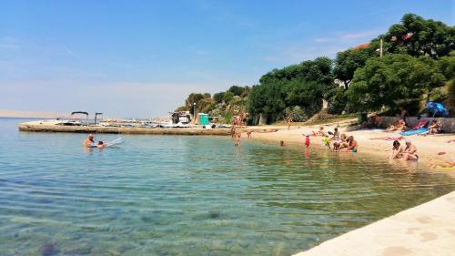 a group of people playing in the water at a beach at Apartments Nicolas - Beach & Sea 10m away - Amazing sea view! in Rtina
