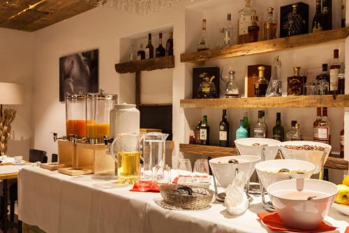 uma mesa com uma toalha de mesa branca e garrafas de álcool em Palace Luxury Wellness Apartment and Boutique Hotel Ski-in-out em Saas-Fee