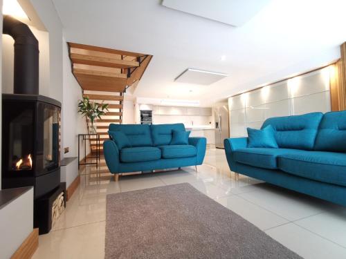 a living room with two blue couches and a fireplace at Twitter Barn in Kirton