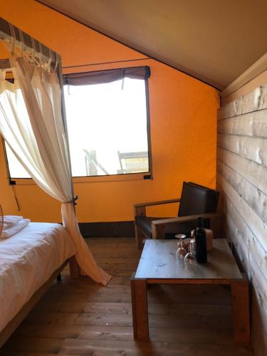 a bedroom with a bed and a table and a window at Castello di Serragiumenta in Firmo
