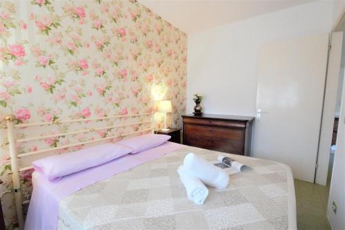 CremiaにあるWhite Houseのピンクの花の壁紙を用いたベッドルーム1室
