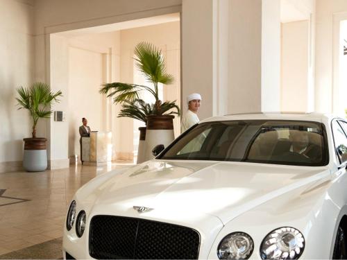 a man standing next to a white car in a building at Jumeirah Al Naseem Dubai in Dubai